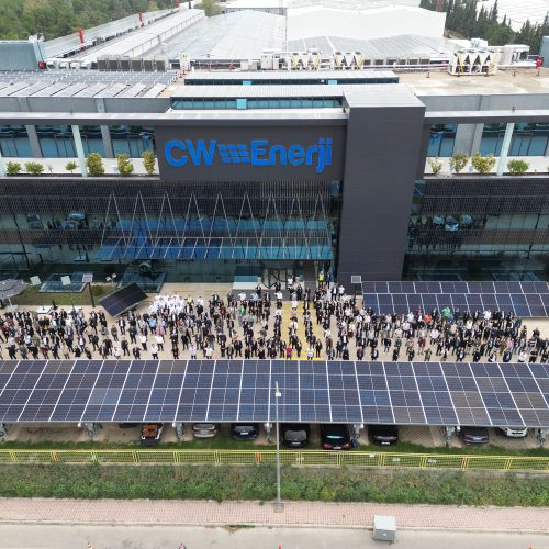 a group of people outside a building with solar panels